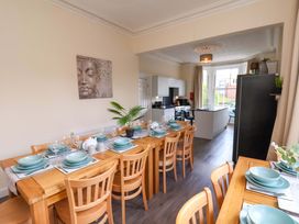 A dining room with a large table set for dinner at The Corner House in Scarborough