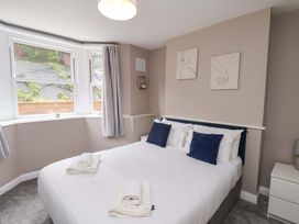 A bedroom with a bed and windows at The Corner House in Scarborough