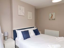 A bedroom with a bed and wall art at The Corner House in Scarborough