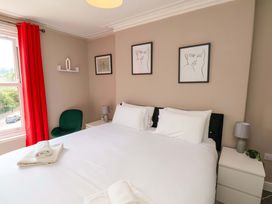 A bedroom with a bed and nightstands at The Corner House in Scarborough