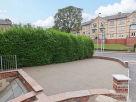 An outdoor area with a hedge and tree at The Corner House in Scarborough