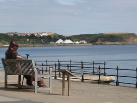 A statue seated on a bench overlooking the sea at The Corner House in Scarborough