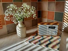 A kitchen featuring flowers in a vase and a radio at Driftwood in Dartmouth