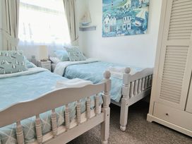 A bedroom with two beds and a wardrobe at Driftwood in Dartmouth