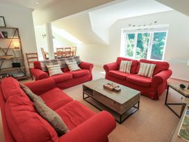 A living room with red sofas and a wooden coffee table at Waterfall in Ambleside