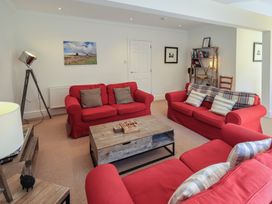 A living room with red sofas and a coffee table at Waterfall in Ambleside