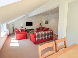 A living room with red sofas and a television at Waterfall in Ambleside