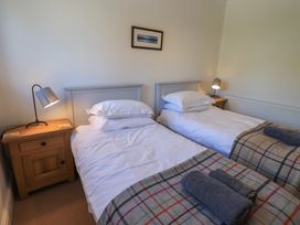 A bedroom with twin beds and bedside lamps at Waterfall in Ambleside