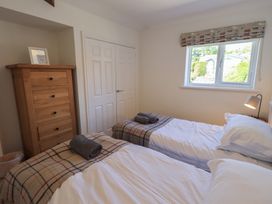 A bedroom with twin beds and wooden drawer unit at Waterfall in Ambleside