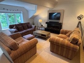 A living room with sofas, a coffee table, and a TV at Waterfall in Ambleside