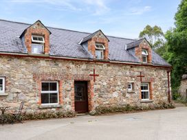 A stone cottage with a pathway and table at Orchard Barn in Wexford