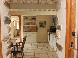 A kitchen with dining table and stone walls at Orchard Barn in Wexford