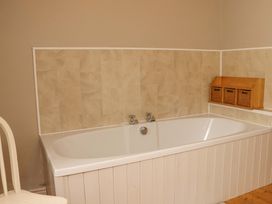 A bathroom with a bathtub and storage baskets at Orchard Barn Wexford