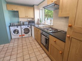 A kitchen with appliances including washing machine, oven, and microwave at 28 Guildford Road