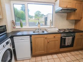 A kitchen featuring a sink, dishwasher, and cooking appliances at 28 Guildford Road