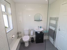 A bathroom with a toilet, sink, mirror, and towel rail at 28 Guildford Road