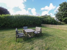 A garden with wooden furniture and a fence at 28 Guildford Road