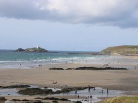 A beach with people and a lighthouse in the background at 28 Guildford Road