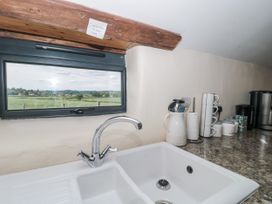 A kitchen with a sink and window overlooking a field at The Bull Pen in Yeovil, Somerset