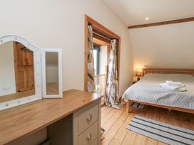 A bedroom with a bed, mirror, and dresser at The Bull Pen in Yeovil, Somerset