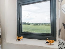 A window with decorative insects on the sill overlooking fields at The Bull Pen in Yeovil, Somerset