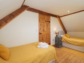 A bedroom with two beds and a door at The Bull Pen in Yeovil, Somerset