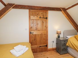 A bedroom with a bed, lamp, and wooden door at The Bull Pen in Yeovil, Somerset
