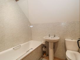 A bathroom with a bath tub and wash basin at The Bull Pen in Yeovil, Somerset