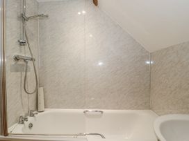 A bathroom with a shower over a bathtub at The Bull Pen in Yeovil, Somerset