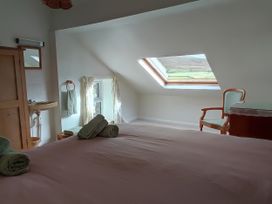 A bedroom with a bed, towels, and a sink at Sally End in Ravenstonedale near Kirkby Stephen