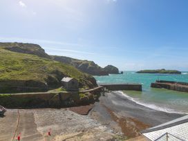 A coastal scene with water and a building at Rowena in Mullion