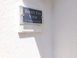 A close up of a wall plaque reading Birds Eye View 37 Tamar Cottage on a white textured wall at 37 Tamar St Ann's Chapel near Callington