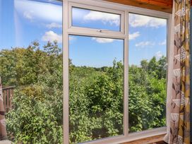 A window with a view of trees and blue sky with clouds at 37 Tamar St Ann's Chapel near Callington