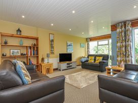 A living room with a sofa and bookshelf at 37 Tamar in St Ann's Chapel near Callington