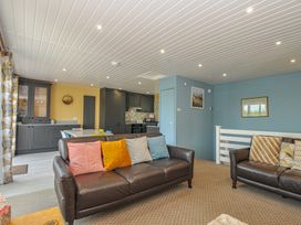 A living room with a kitchen area and sofas at 37 Tamar in St Ann's Chapel near Callington