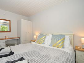A bedroom with a bed and mirror at 37 Tamar, St Ann's Chapel near Callington