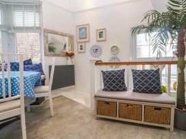 A dining room with blue table and cushions at Harbour View St Ives