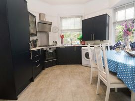 A kitchen with appliances and a dining table at Harbour View in St Ives