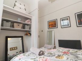 A bedroom with a bed and shelves at Harbour View in St Ives