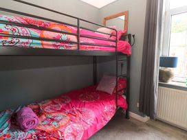 A bunk bed with colorful bedding in a bedroom at Harbour View St Ives