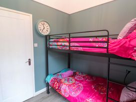 A bedroom with a bunk bed and wall clock at Harbour View in St Ives