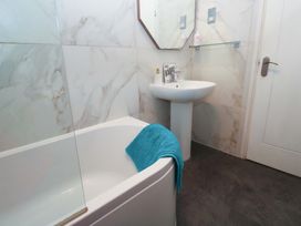A bathroom with a bathtub and sink at Harbour View in St Ives