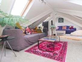 A loft with a sofa, coffee table, and decorative items at Harbour View in St Ives