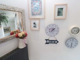 An entryway with decorative wall art and a flower arrangement at Harbour View in St Ives