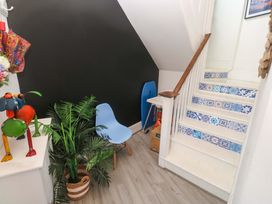 A hallway featuring a blue chair and a decorative lamp at Harbour View in St Ives