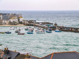 A view of boats in the ocean near a pier at Harbour View in St Ives
