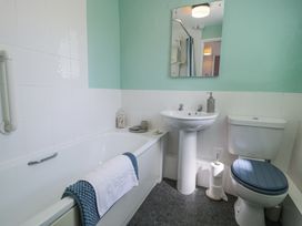 A bathroom with a bathtub towels sink mirror and toilet at Pen Y Bryn Bach in Harlech