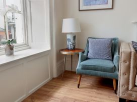 A living room with an armchair and side table at FLAT 1 53a Broad Street (1 Bedroom Sleeping 2) Lyme Regis