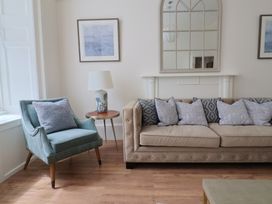 A living room with an armchair and sofa at FLAT 1 53a Broad Street (1 Bedroom Sleeping 2) Lyme Regis