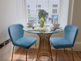 A dining room with a table and two chairs at FLAT 1 53a Broad Street (1 Bedroom Sleeping 2) Lyme Regis